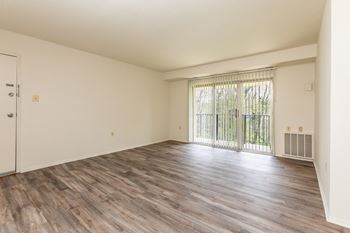 Bedroom with hardwood flooring and a door leading to a balcony